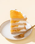 Mango Vegan Naked Cake with fluffy vanilla sponge layers, creamy vegan mango frosting, and fresh mango cubes on top, offering a tropical and dairy-free dessert option.