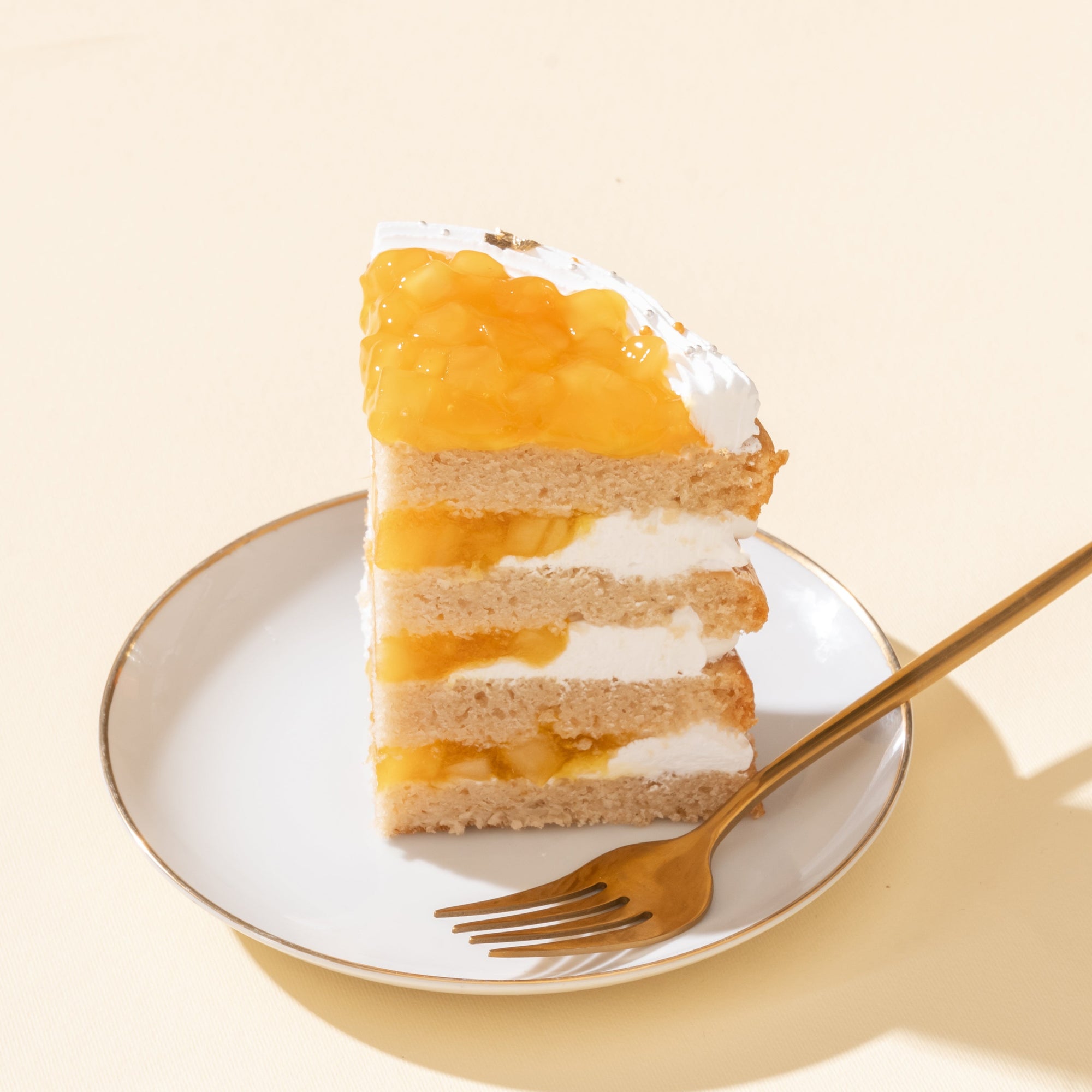 Mango Vegan Naked Cake with fluffy vanilla sponge layers, creamy vegan mango frosting, and fresh mango cubes on top, offering a tropical and dairy-free dessert option.